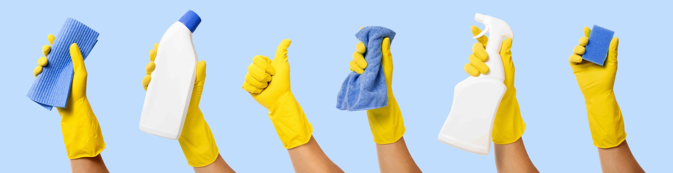 Hand holding cleaning products against a blue background