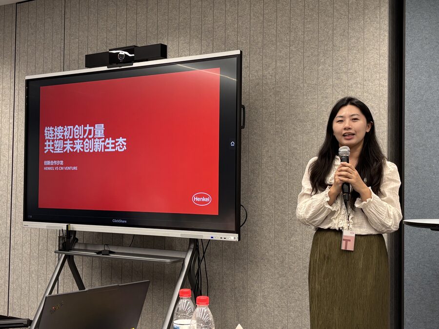Xiwen Qing of Henkel speaking beside a presentation screen